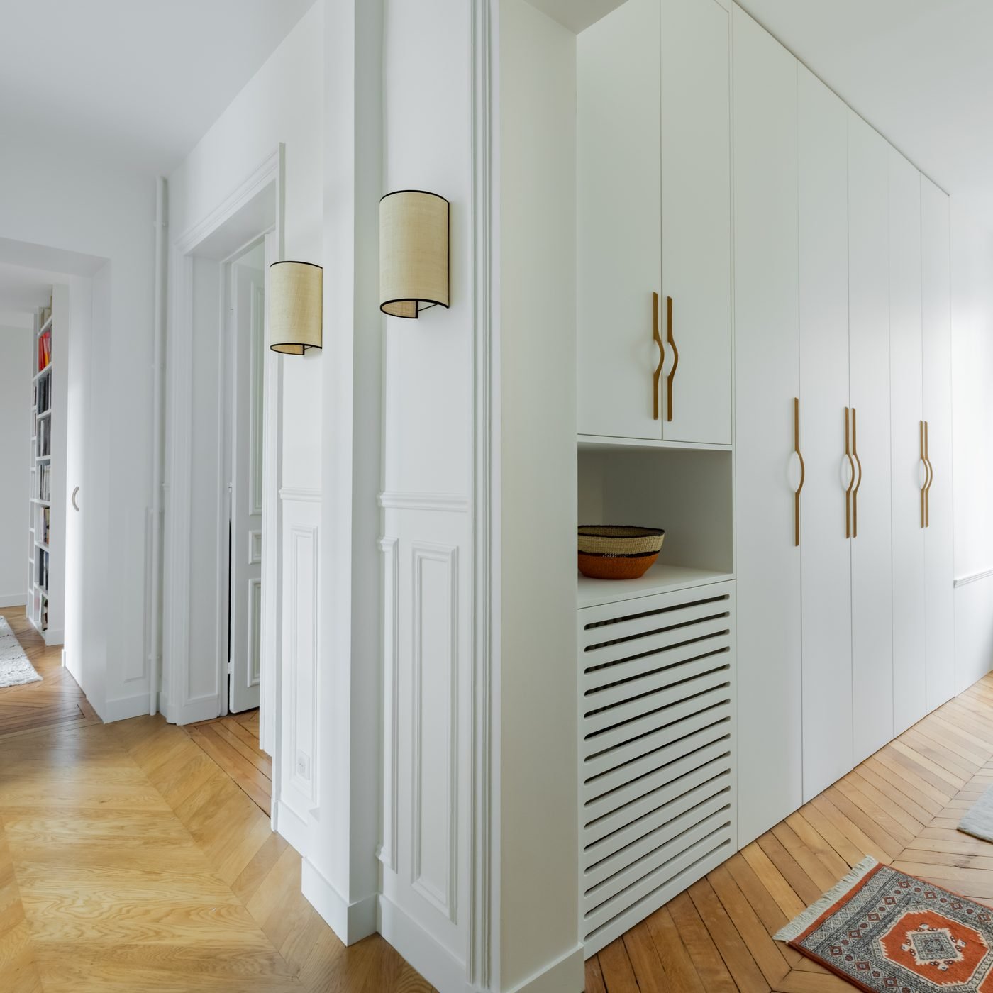 Dressing sur mesure intégré dans un couloir haussmannien à Paris 16e, parquet à chevrons et moulures
